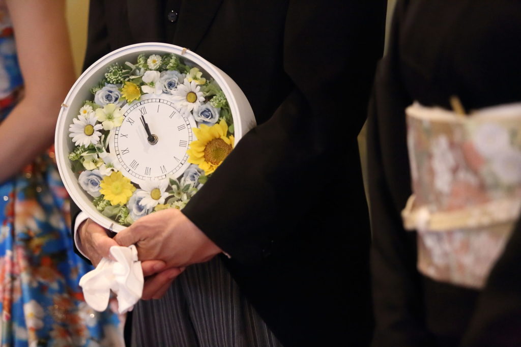 贈呈品を持つ父親とブーケを持つ花嫁のフリー写真素材